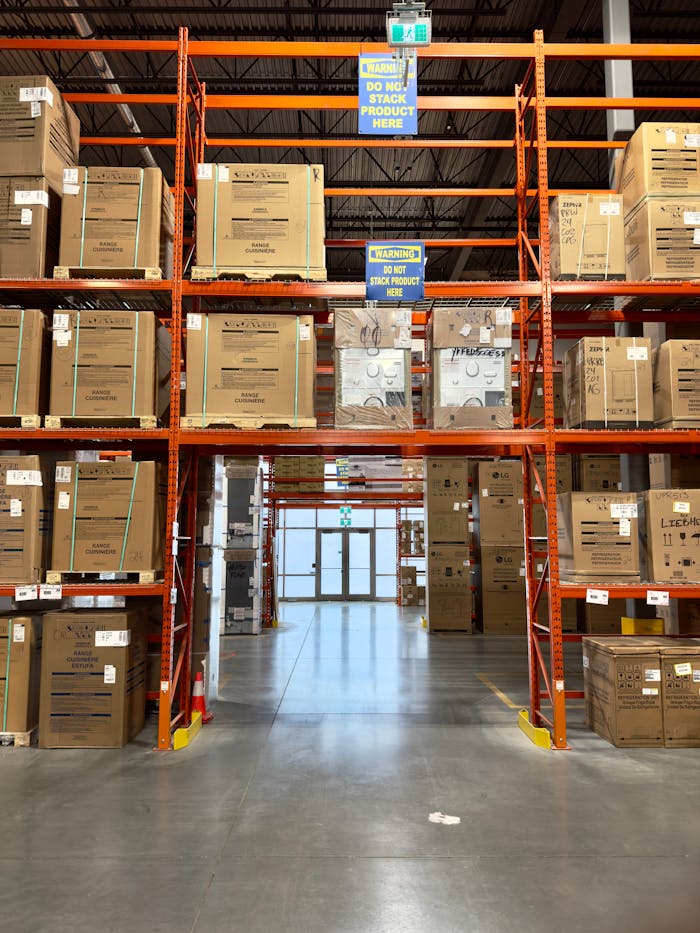 Large warehouse interior with racks filled with cardboard boxes, offering ample storage space.